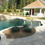 A stone patio with a swimming pool